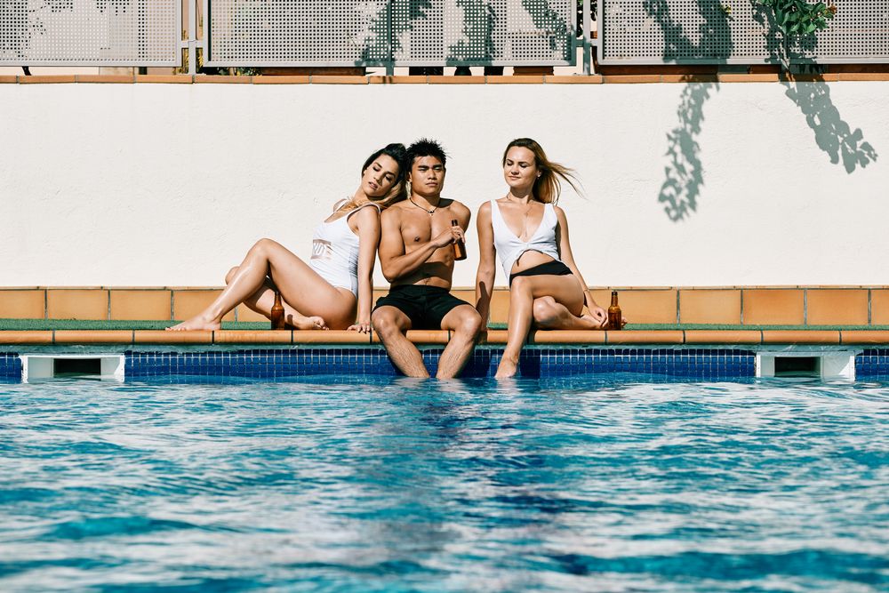 a group of young models by the pool in a summer day