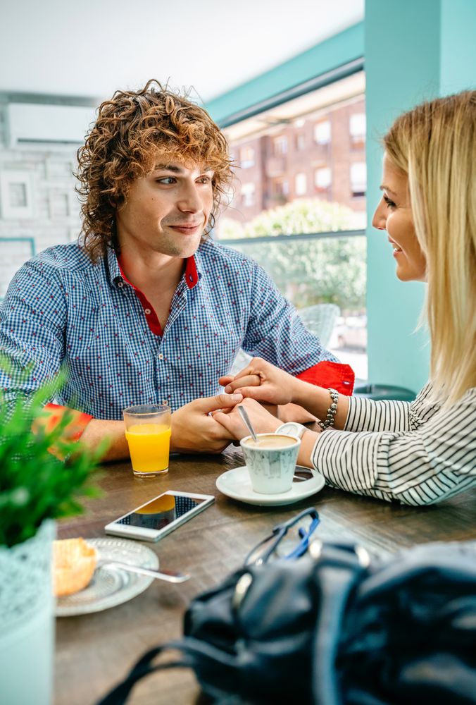 Couple holding hands at a cafe