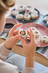 Crop boy eating sushi rolls