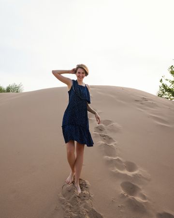 Woman in dress posing  on sand dunes