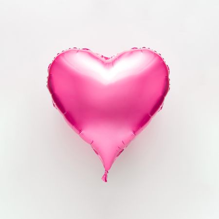 Pink heart balloon on light background