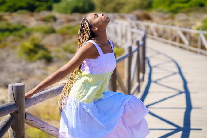 Female leaning back on a pedestrian walkway in colorful dress
