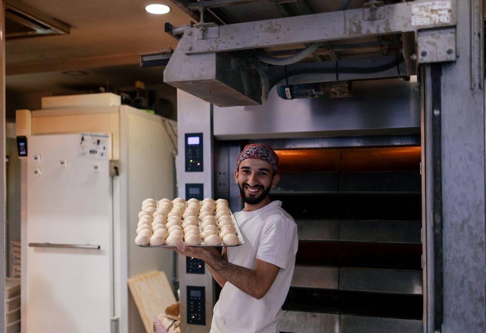 Arabic baker with tray with dough balls