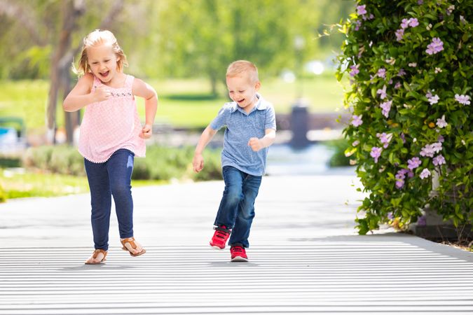Young Sister and Brother Having Fun Running At The Park