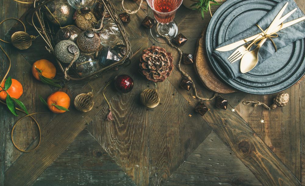 Top view of table setting with glass of rose Champagne, pinecone, and candle, with copy space