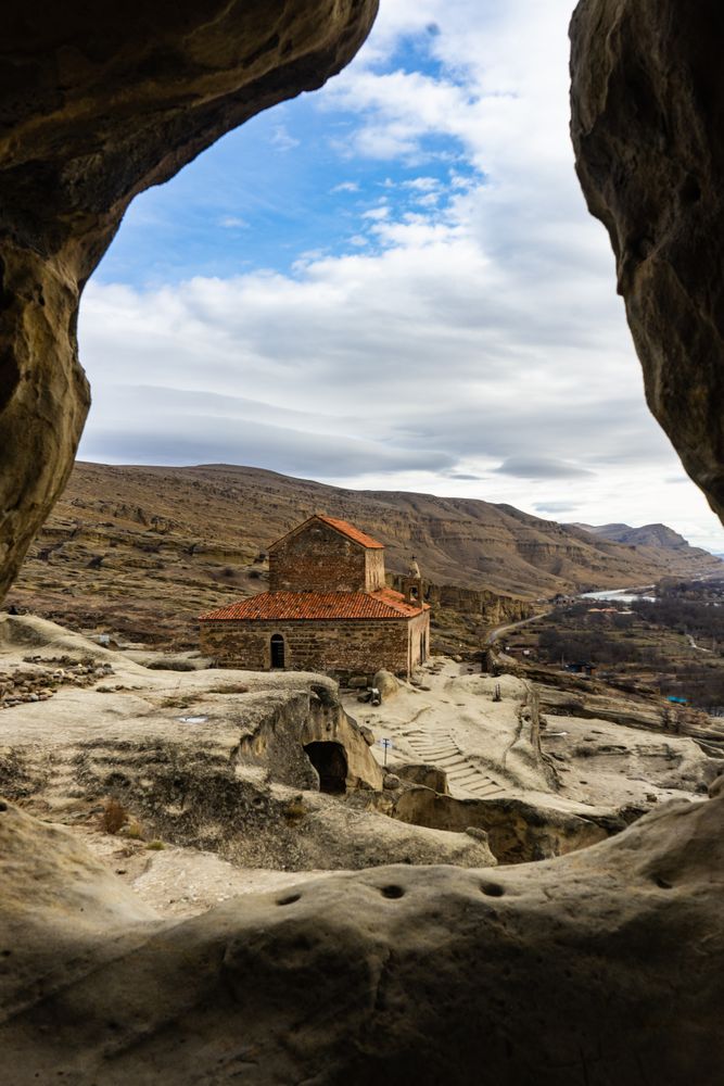 Ruins of ancient rock city Uplistsikhe close to Gori in Shila Kartli region, Georgia seen through mountains