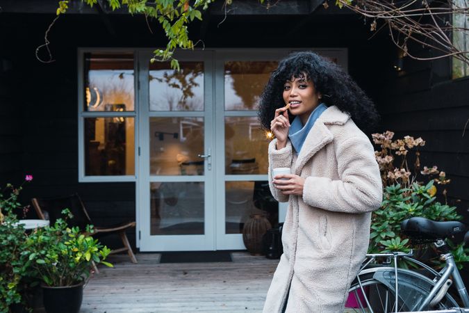 Cheerful Black woman eating cookie