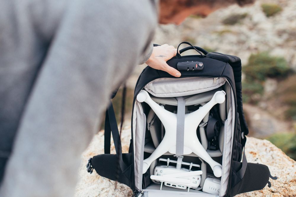 Man with backpack containing a drone
