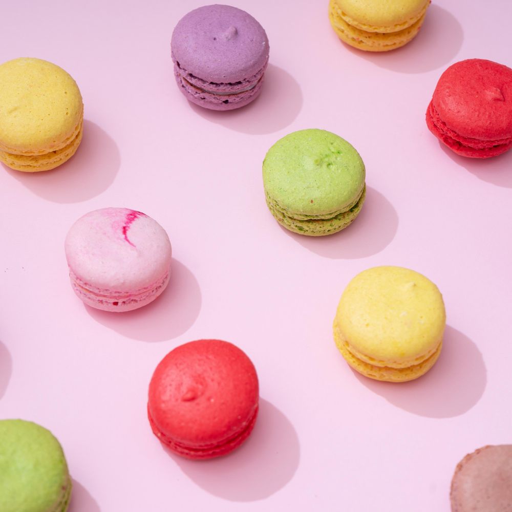 Pastel pink table top with colorful macarons pattern