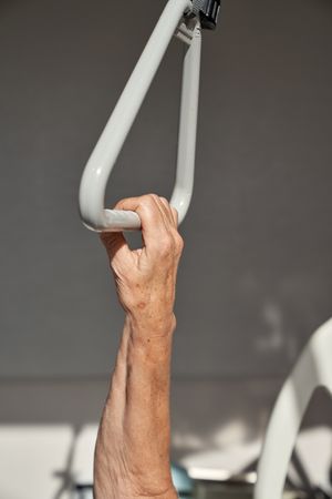 Crop faceless patient holding handle in clinic