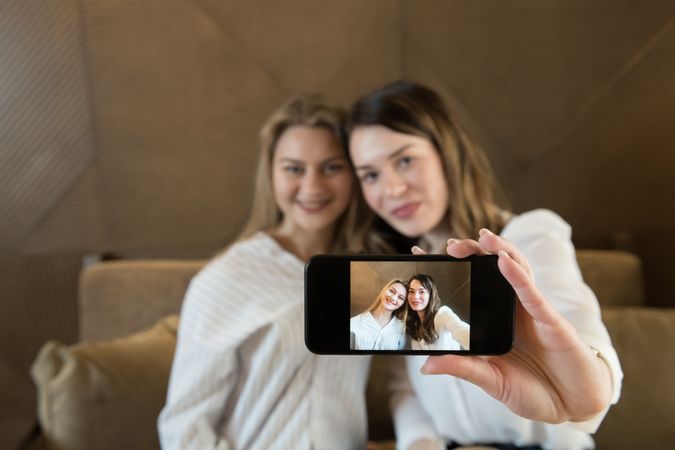 Young women taking selfie in cafe