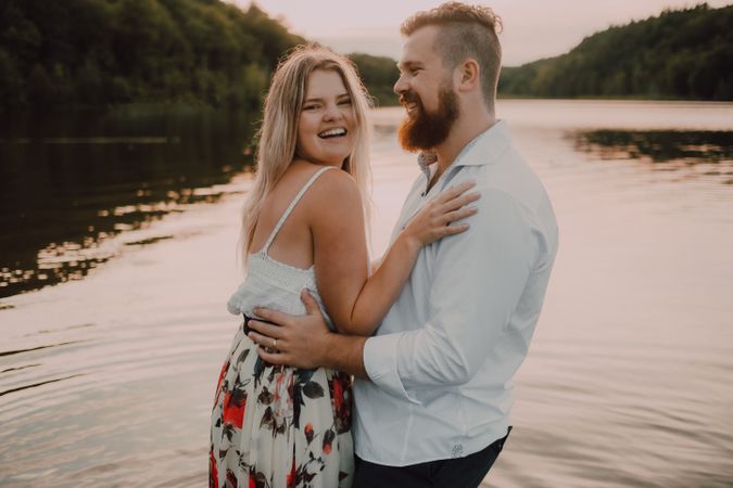 Loving couple standing ankle deep in water on beach