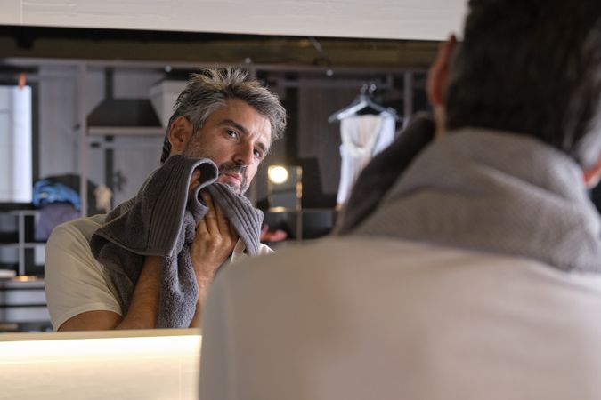 Adult man wiping face with towel