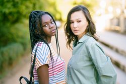 Two serious women in casual clothing posing in park walk way