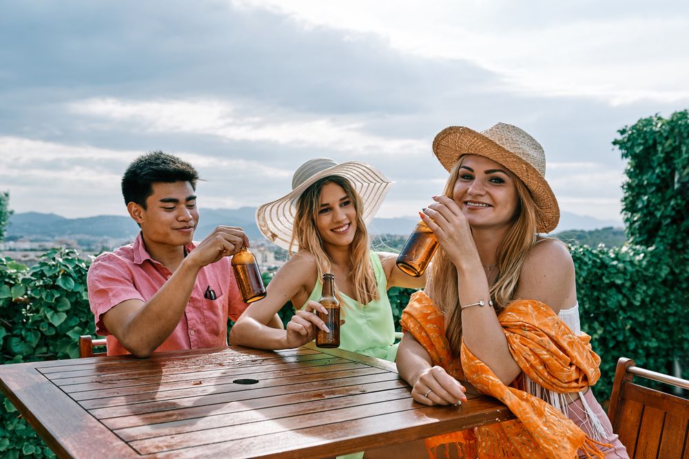 a group of young people having a good time in a summer day and cheering with beer