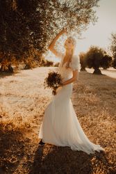 Charming woman in elegant dress with flowers near tree