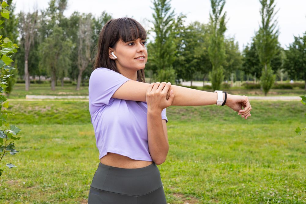 Woman arm stretching exercise outdoors