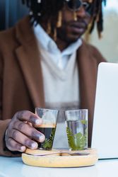 Serious Black man with espresso and glass of water in cafe