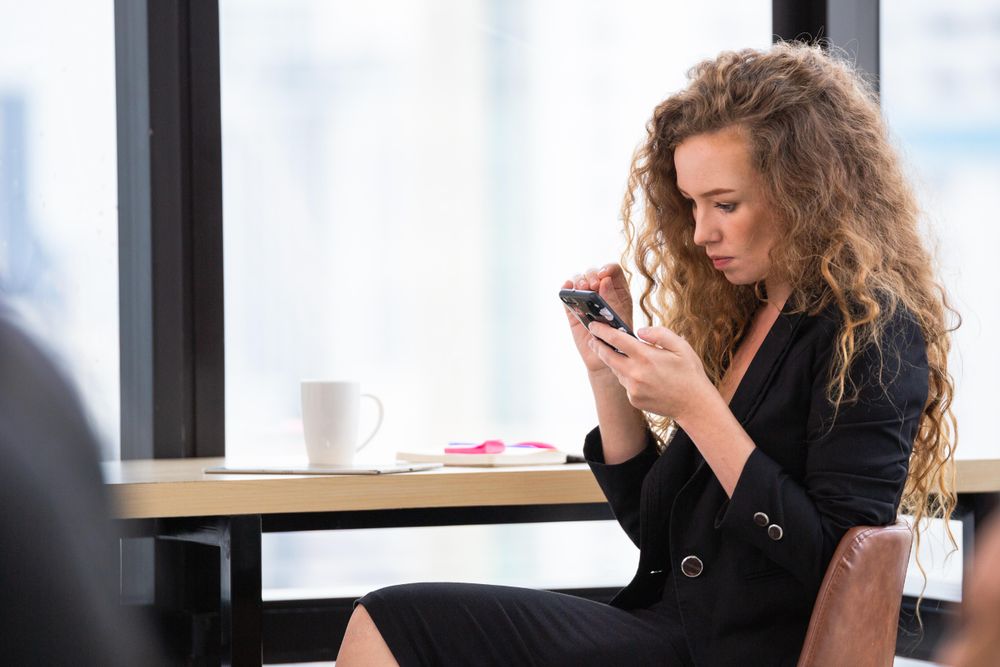 Businesswoman using mobile phone at seat