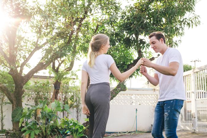 Man taking wife’s hand outside for a casual dance