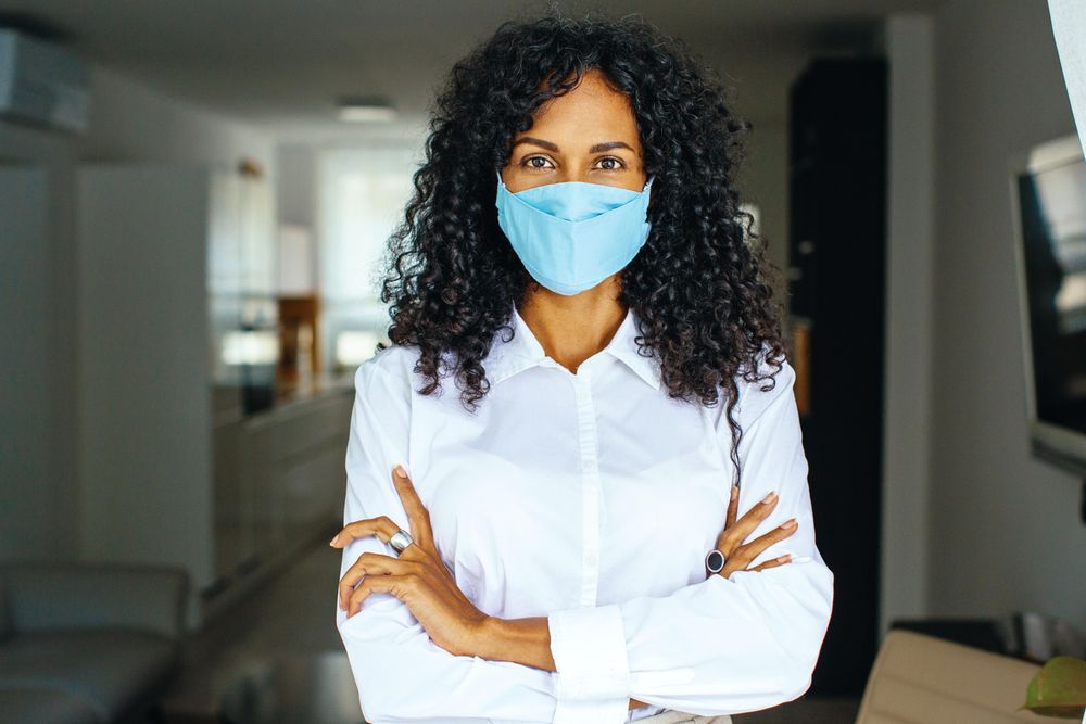 Portrait of confident woman in facemask with her arms crossed