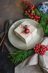 Christmas holiday concept of present on plate garnished with holly