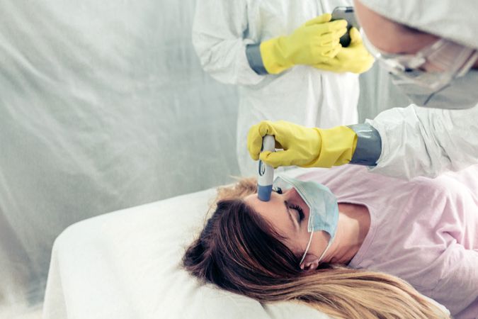Doctors in a field hospital taking the fever a patient