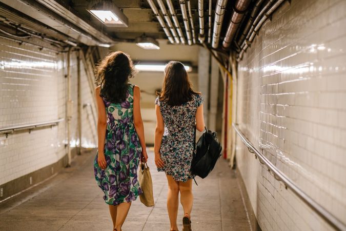 Back view of two women walking in hallway