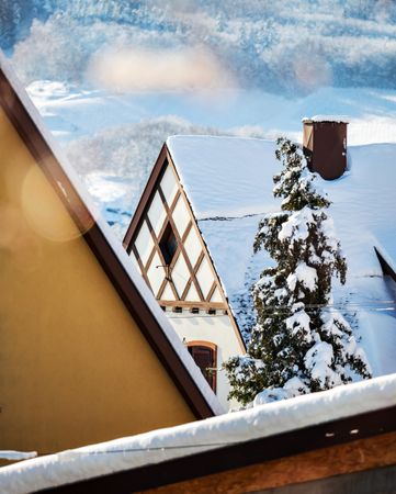 Sunny winter day. Snow-covered roofs of houses. Village in Alsace.