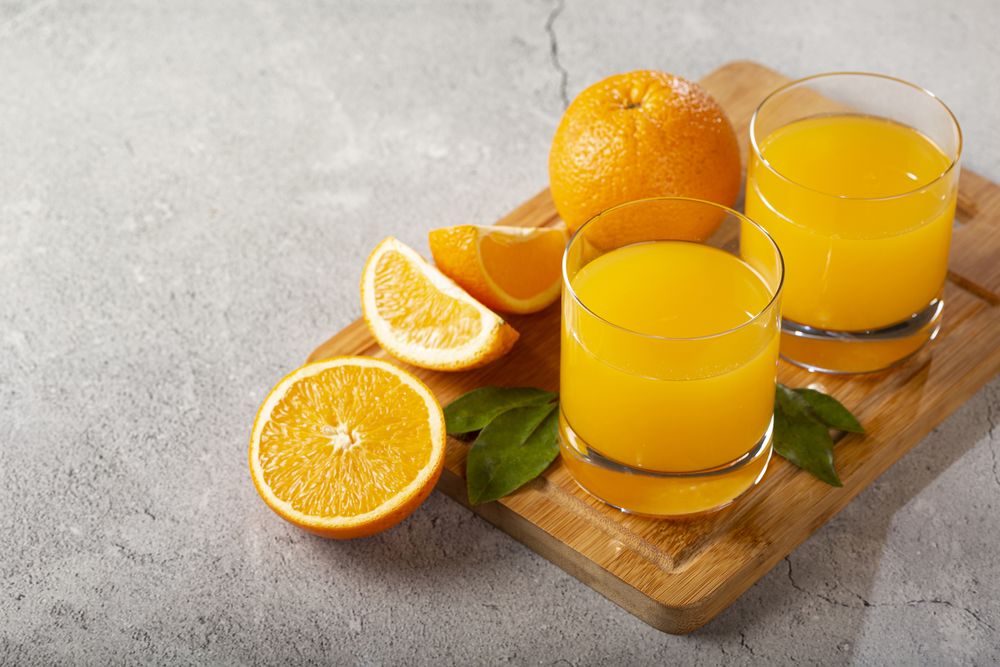 Glass with orange juice on the table.