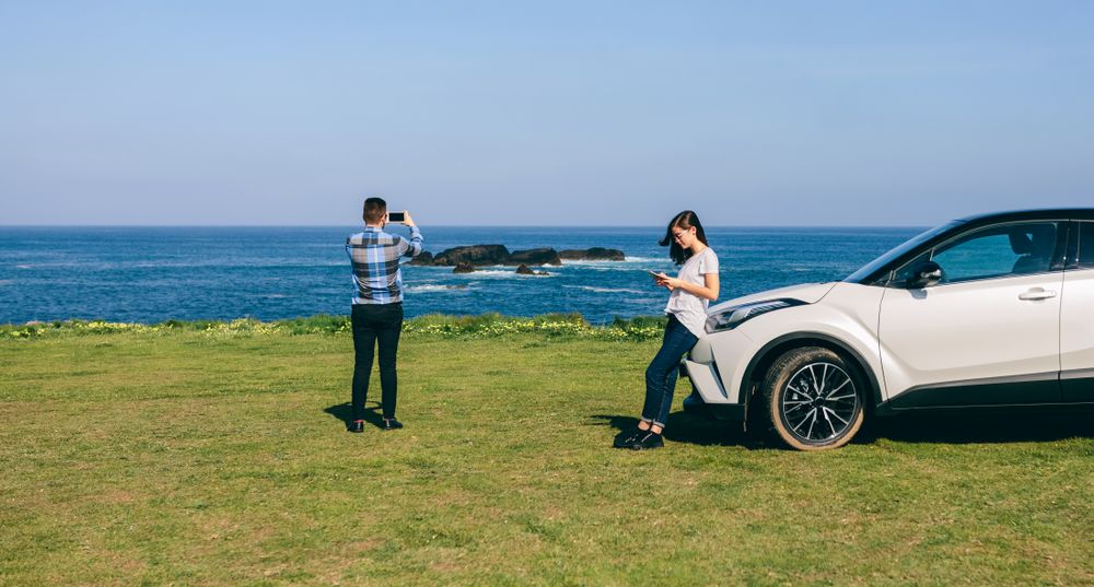 Couple traveling by car photographing the landscape