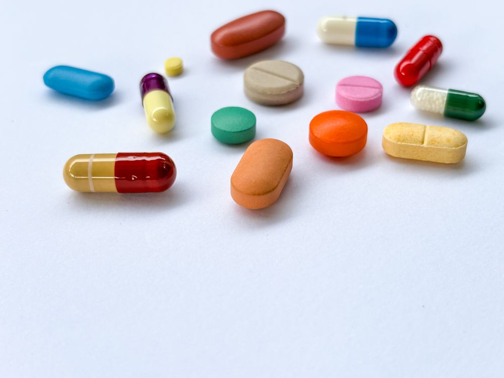 Assorted Colorful Pills and Capsules on Light Background