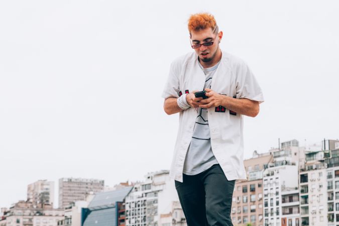 Contemporary male in casual trendy browsing phone