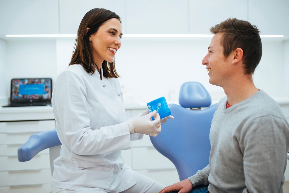 Dentist smiling and speaking with client showing material in blue
