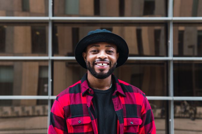 Cheerful Black man in stylish outfit on street