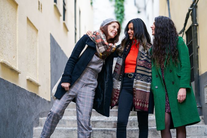 Three female friends dressed in fall attire together on a walk