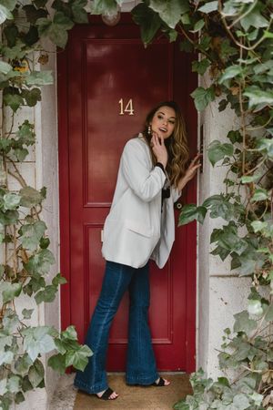Stylish woman looking away near red door