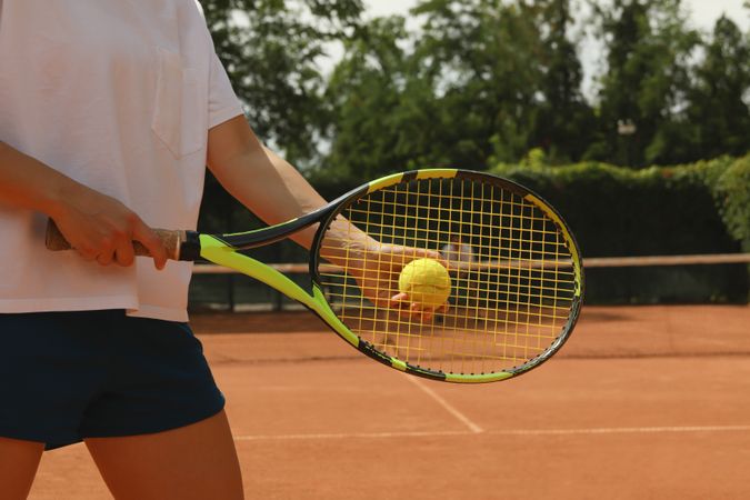 Woman hold racket and tennis ball on clay court