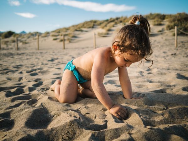 Girl playing on beach in sunny day