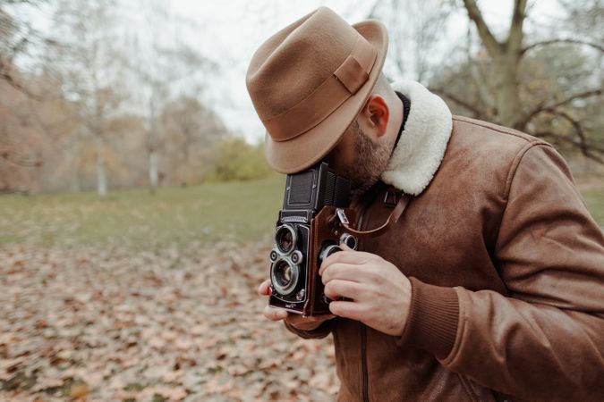 Male photographer standing in autumn park
