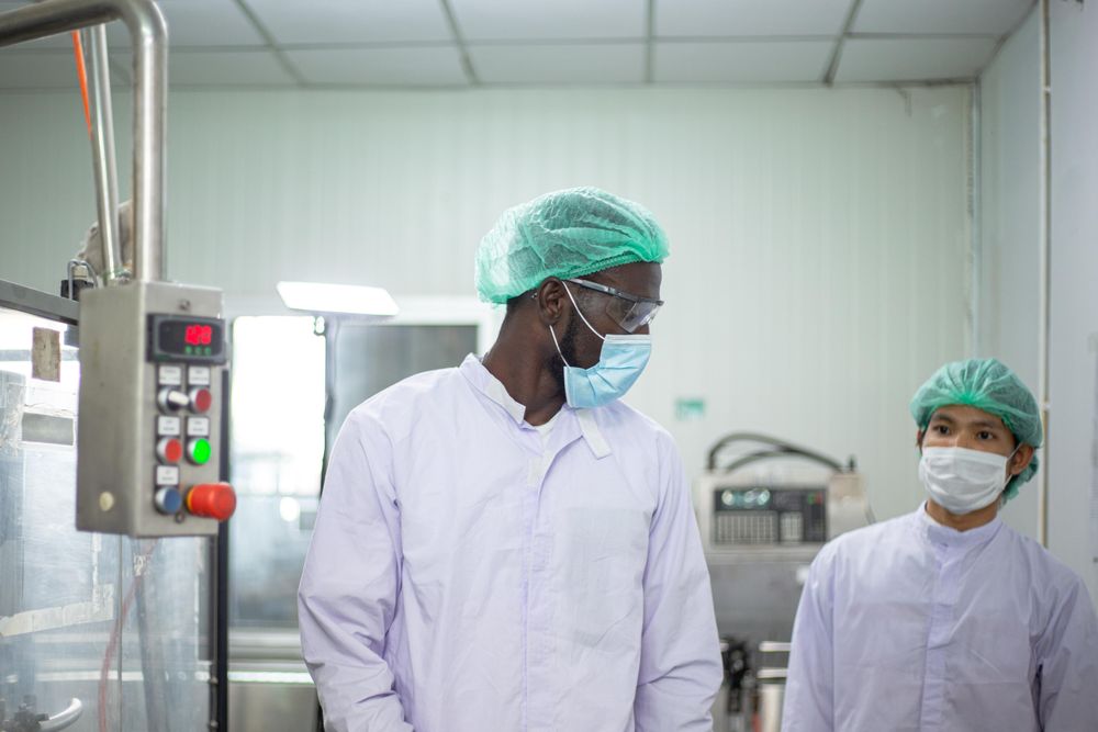 Black man and Asian male worker talking at work