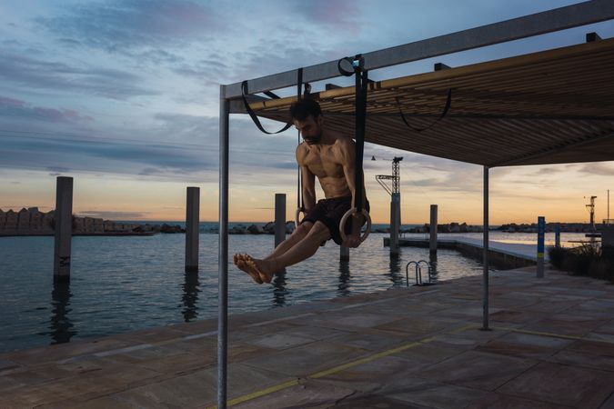 Athletic man balancing on gymnastic rings