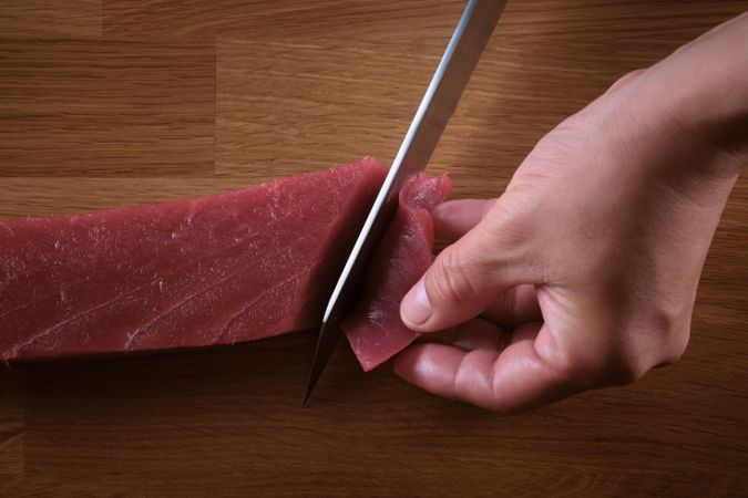 Male hands slicing fresh bluefin tuna loin