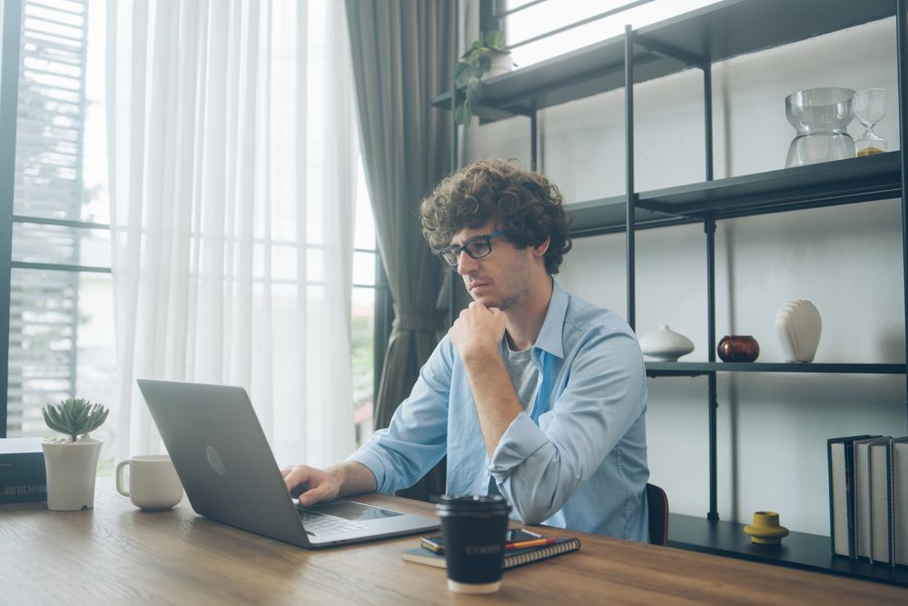 Creative designer reading emails on laptop on desk