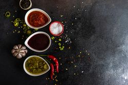 Top view of three spicy colorful Georgian condiments with copy space