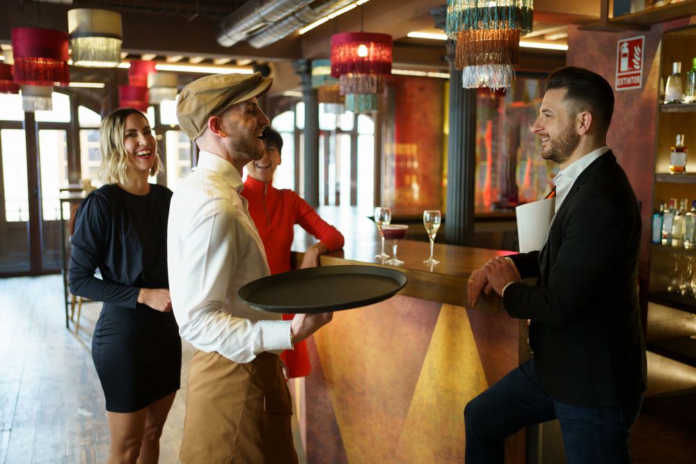 Bartender laughing with guests in bar