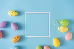 Colorful Easter eggs with square frame and pastel blue background