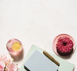 Sunny office desk flat lay on light marble with roses
