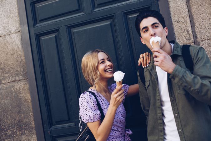 Happy couple feeding each other by ice cream