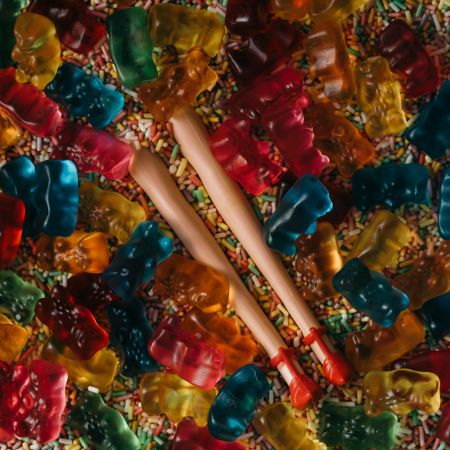 Doll legs buried in colorful sprinkles and gummy bears